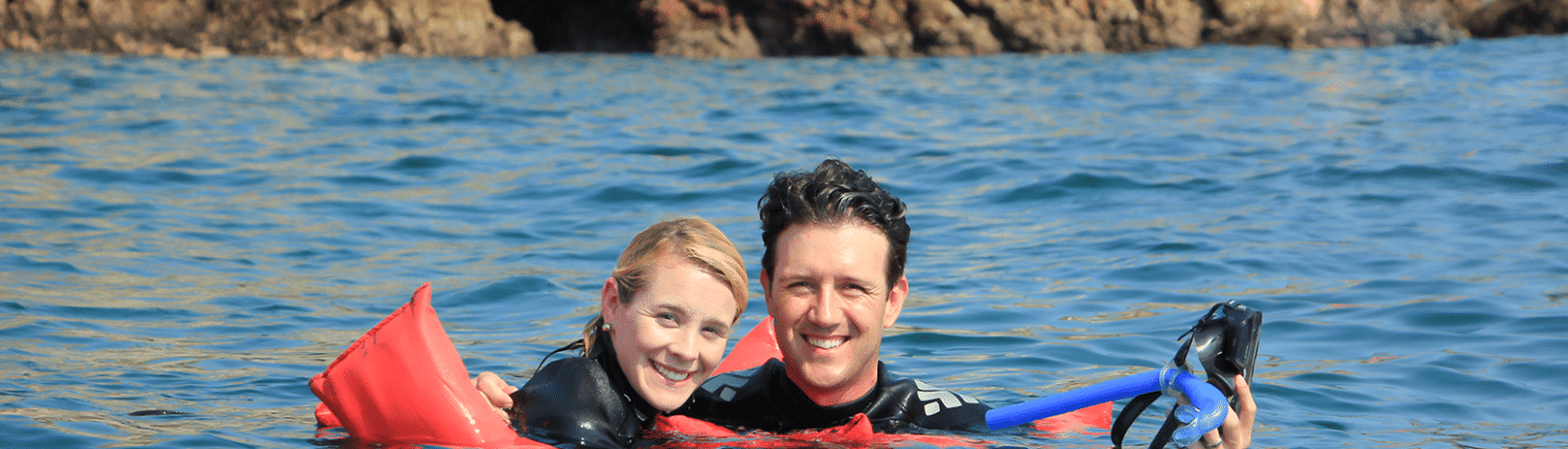 Young smiling couple in the water with snorkelling gear