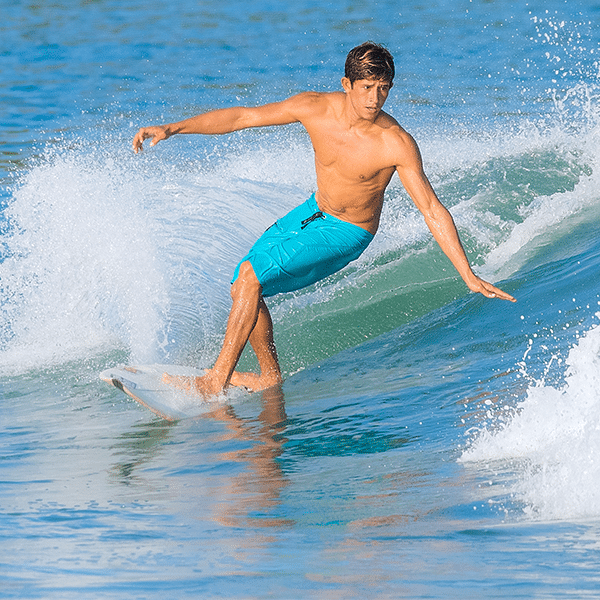 Young male surfer riding a wave in Riviera Nayarit Mexico