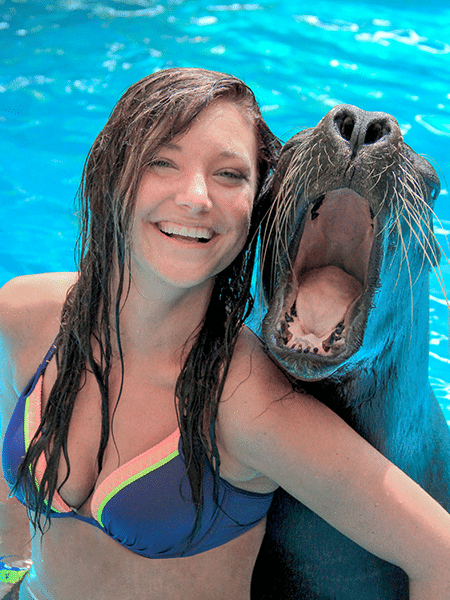 Young girl and sea lion laughing together