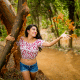 Young female tossing next to a tree tossing tree bark in the air